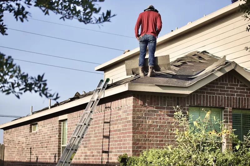 Professional roofer working on a residential roof in West Goshen Park